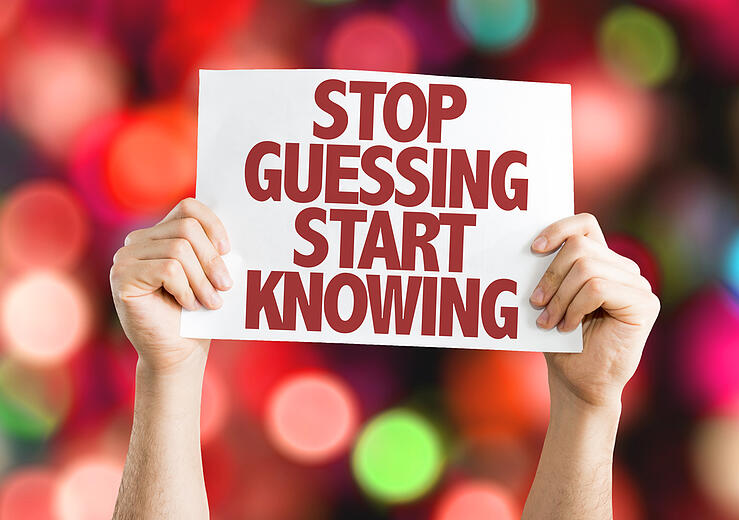 Stop_Guessing_Start_Knowing_placard_with_bokeh_background.jpeg